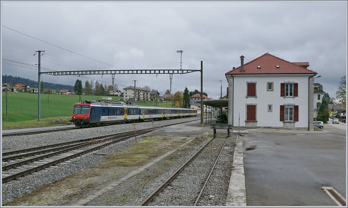 Der RE 18124 Neuchâtel (12:06) nach Frasne (13:06) bei der Durchfahrt in Les Verrières. Der Zug besteht aus folgenden Fahrzeugen: RBDe 560 004-2, AB 50 85 30-35 603-1, B 5085 20-35 600-9, B 85 20-35 602-5 und dem führenden Bt 50 85 29-35 952-5. Les Verrières, ein Fahrdienstlich bedienter Bahnhof mit Wartesaal und Billettschalter, letzterer reichlich an Prospekten bestückt aber geschlossen. Mit nur drei Zugspaaren, die ohne Halt den Bahnhof passieren, dürfte Les Verrière eine am wenigsten frequentierten Bahnhöfe der Schweiz sein.

29. Okt. 2019