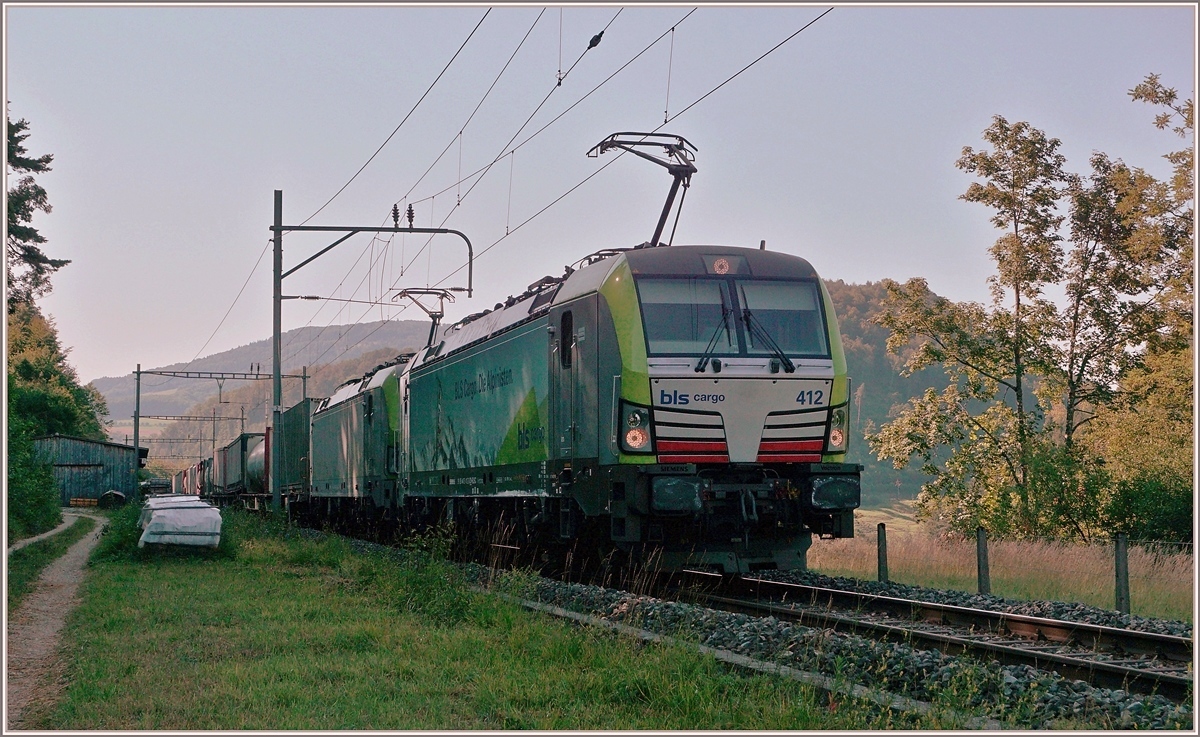 Die BLS Re 475 412 und eine weitere fahren im Schatten mit einem via Alte Hauensteinlinie umgeleiteten Güterzug Richtung Sissach. Der Zug fährt gerade durch den Bahnhof Sommerau und wird in Kürze eine Stelle erreichen die sich  Gotthard  nennt.
18. Juli 2018