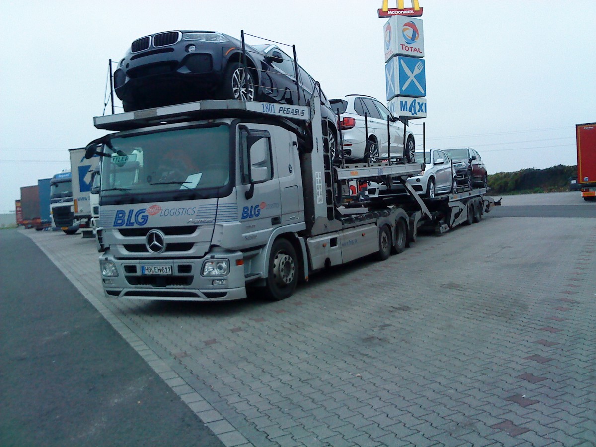 LKW Mercedes-Benz Actros Autotransporter der Spedition BLG Logistics beladen mit nagelneuen BMW auf dem Autohof in Grnstadt am 20.11.2013