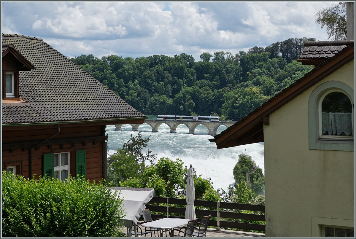 Rheinfall - ein Nischennbild gibt den Blick frei auf den Rheinfall und eine Thorbo GTW welcher die Rheinbrcke bei Neuhausen berquert.

18. Juni 2016