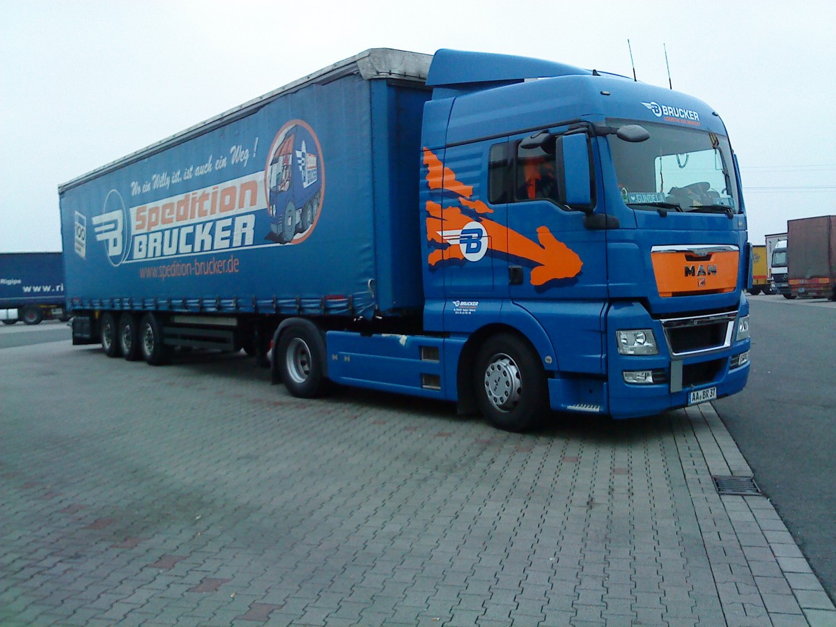 SZM MAN TGA mit Pritsche-Planen-Auflieger der Spedition Brucker auf dem Autohof in Grnstadt am 20.11.2013