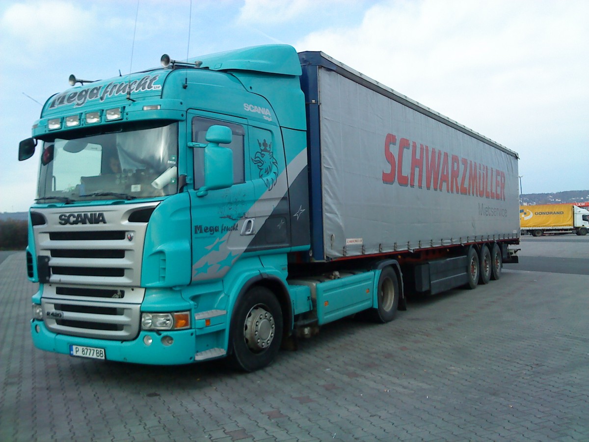 SZM SCANIA R 420 mit Schwarzmller Pritsche-Planen-Auflieger der Firma Mega-fruit gesehen auf dem Autohof in Grnstadt am 19.02.2014