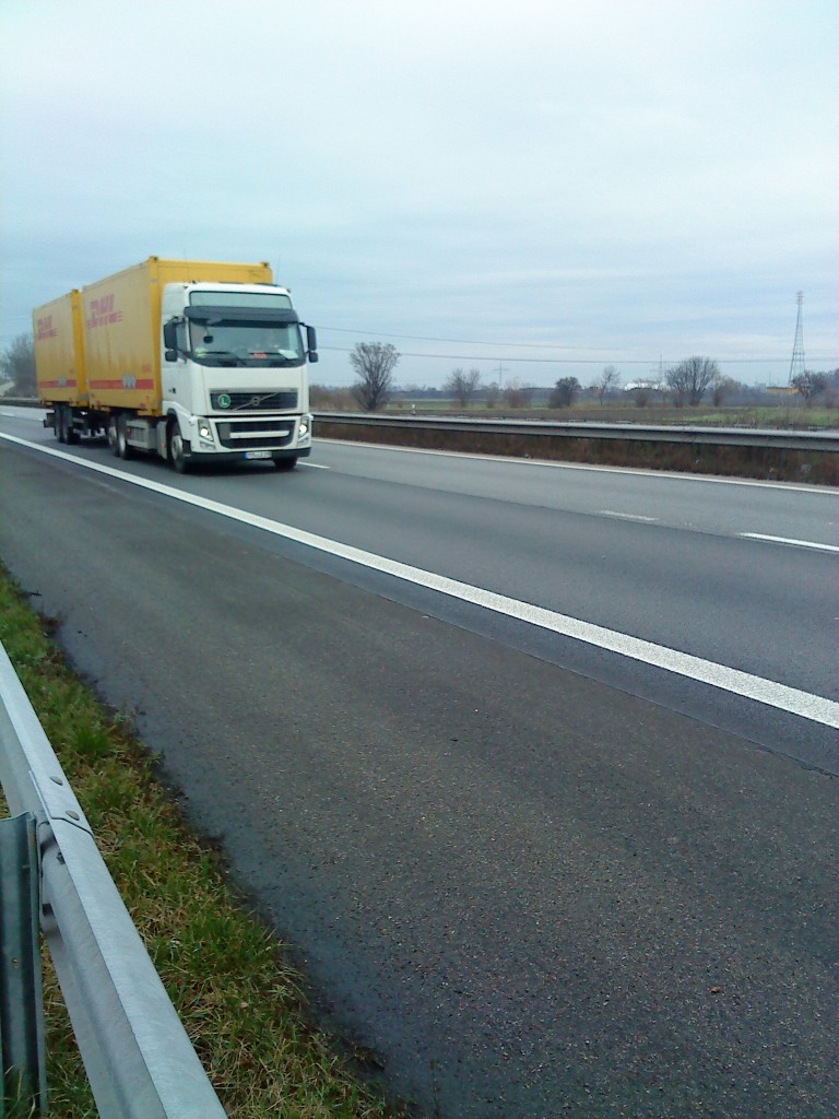 Volvo FH Hngerzug mit Container-Pritsche beladen mit DHL Container, gesehen auf der A 61, Hhe Raststtte Dannstadt, am 16.01.2014 