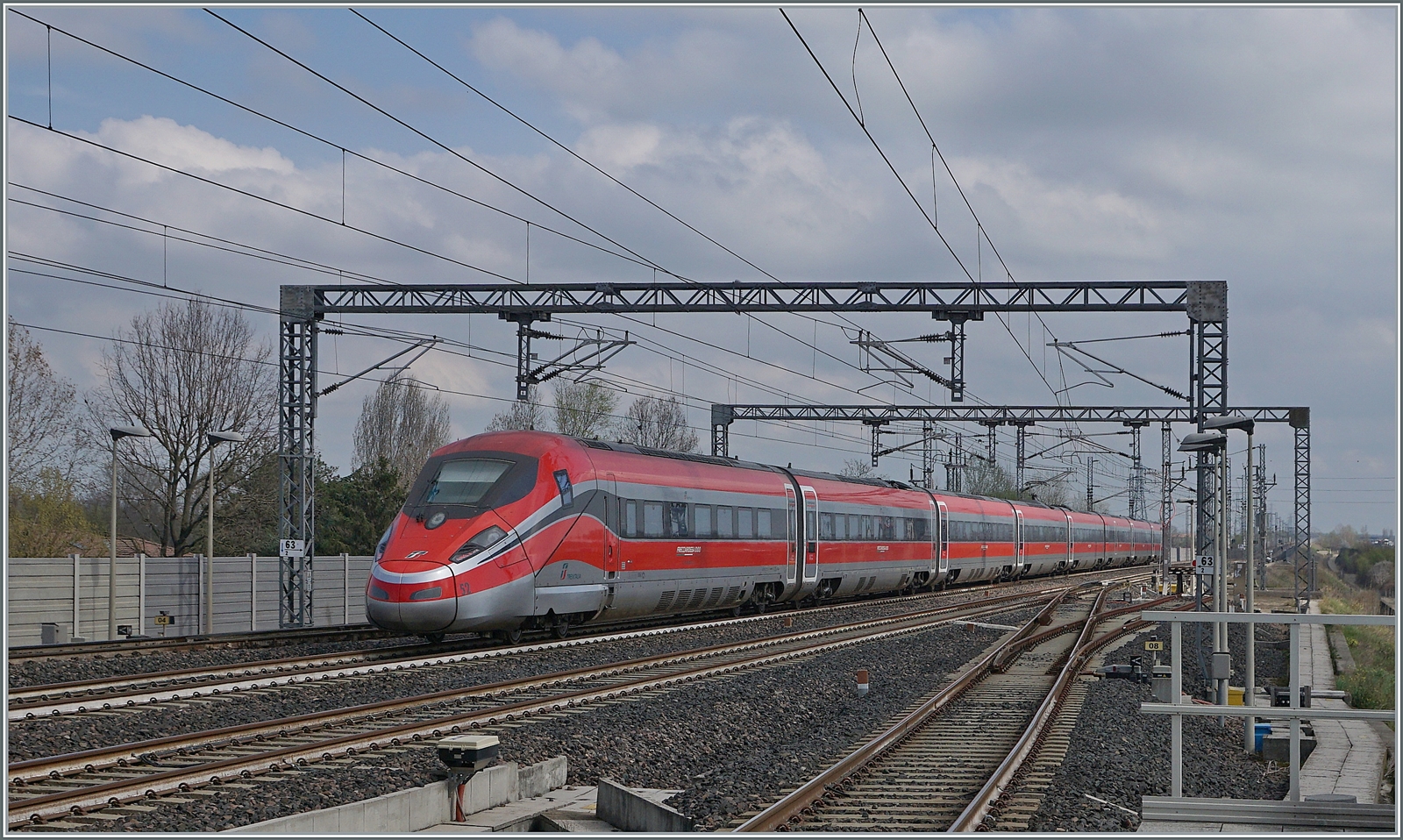 Der nachfolgende FS Treniatlia wird durch den voraus gefahrenen Zug etwas abgebremst. Der ETR 400 052 ist als Frecciarossa 1000 9631 von Milano (ab 13.00) nach Napoli (an 17:30) unterwegs. 

14. März 2023