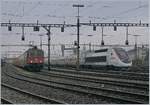 Während der TGV 4415 Lyria  im Rangierbahnhof von Biel auf seine nächsten Einsatz wartet, fährt eine SBB RE 4/4 II mit eienem Güterzug aus.