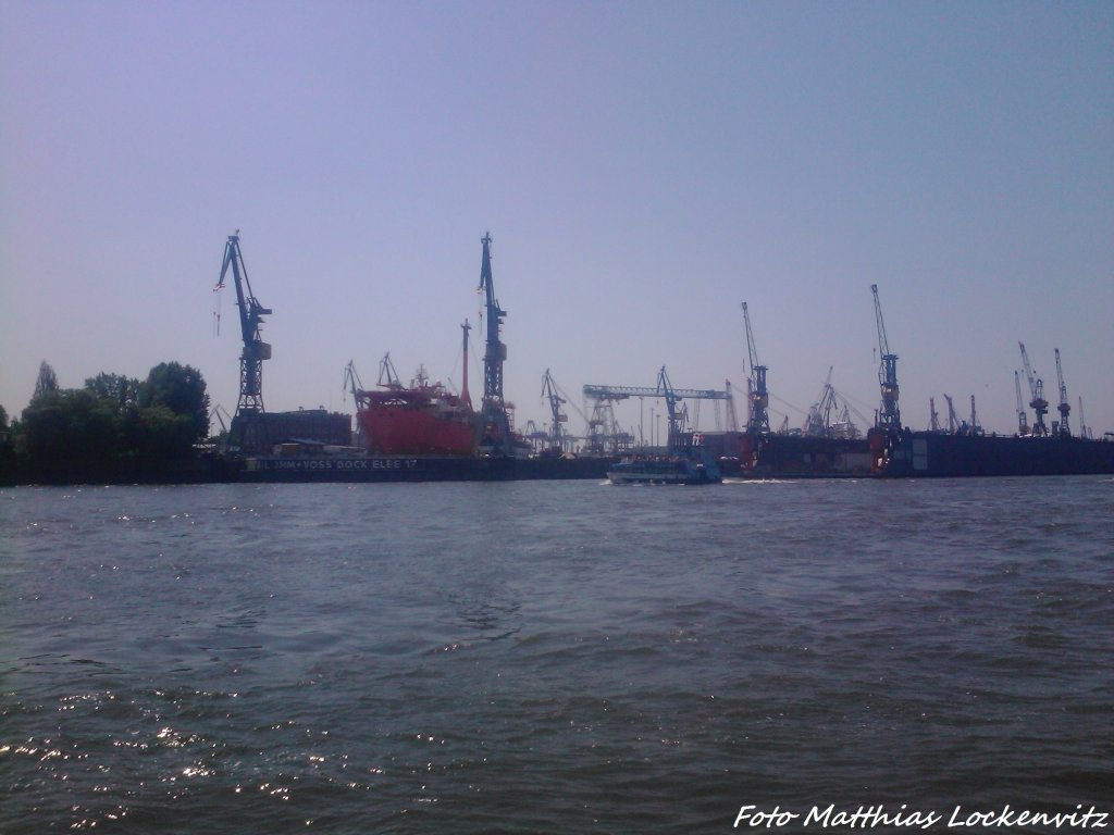 Blick auf den Frachthafen von Hamburg und vor dem Frachthafen fhrt ein Kleines Ausflugsschiff vorbei am 8.6.13