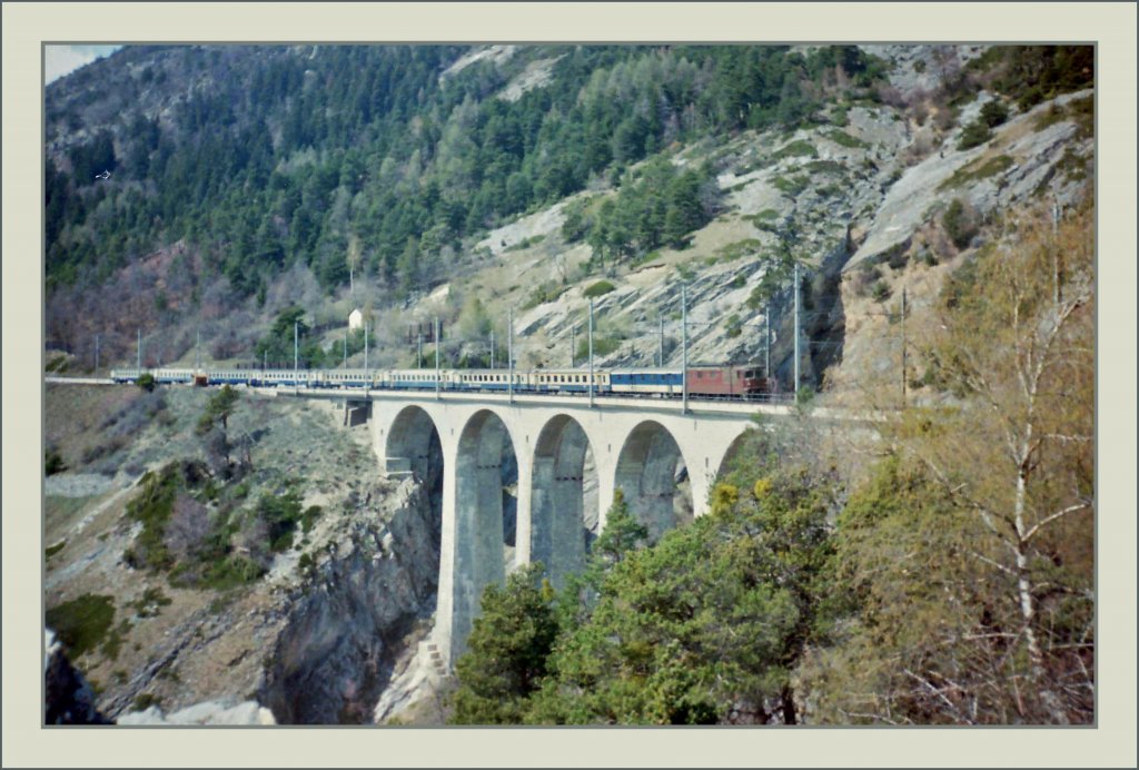 BLS Re 4/4 mit einem Schnellzug auf dem Luogelkin Viadukt bei Hohtenn. 
Scan/ Frhling 1993