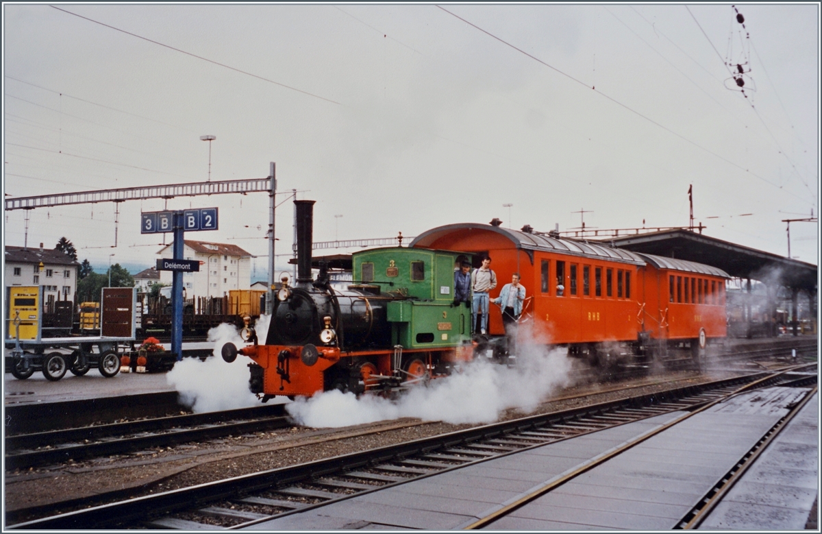 150 Jahre Schweizer Eisenbahn:  Die E 2/2 N� 3  Zephir  verl�sst mit zwei RHB Wagen den Bahnsteige des Bahnhof von Del�mont in Richtung  Festgel�nde  bei der Drehscheibe im �stlichen Teil des Bahnhofs. 

Die 1974 von der Lokomotivfabrik Krauss & Cie, M�nchen gelieferte E 2/2 N� 3  Zephir  wurde mit ihren Vorg�ngern E 2/2 1 und 2 auf der  B�delibahn  eingesetzt. 

Analog Bild vom Sommer 1997
