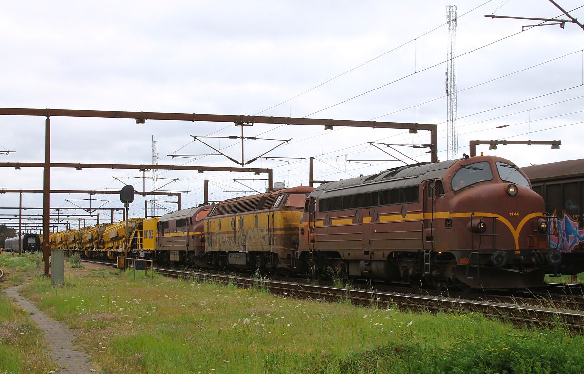 CFL-Cargo DK MY 1146 + 1831 + MX 1029 warten mit dem langen Spitzke Bettungsreingungszug RM 900 S in Pattburg/DK auf Ausfahrt Richtung Norden. Der EC von Kopenhagen nach Hamburg ist soeben eingetroffen. 27.07.2022  