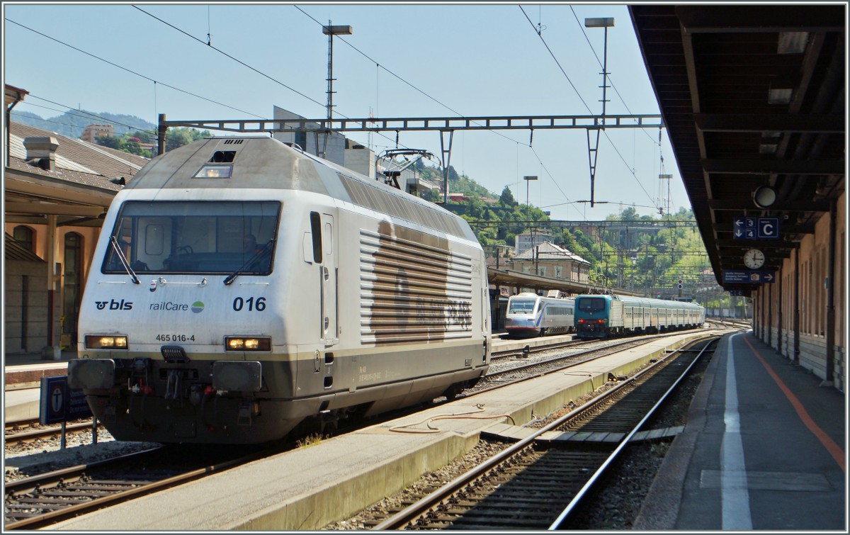 Chiasso, oder Kilometer 206 der Gotthardbahn. Hier im Grenzbahnhof werden die Züge von der italienischen Bahn zur Weiterfahrt Richtung Süden übernommen. 
Im Bild die BLS Re 465 016-4  Black Pearl  sowie im Hintergrund ein SBB ETR 470 und ein FS Regionalzug.
5. Mai 2014