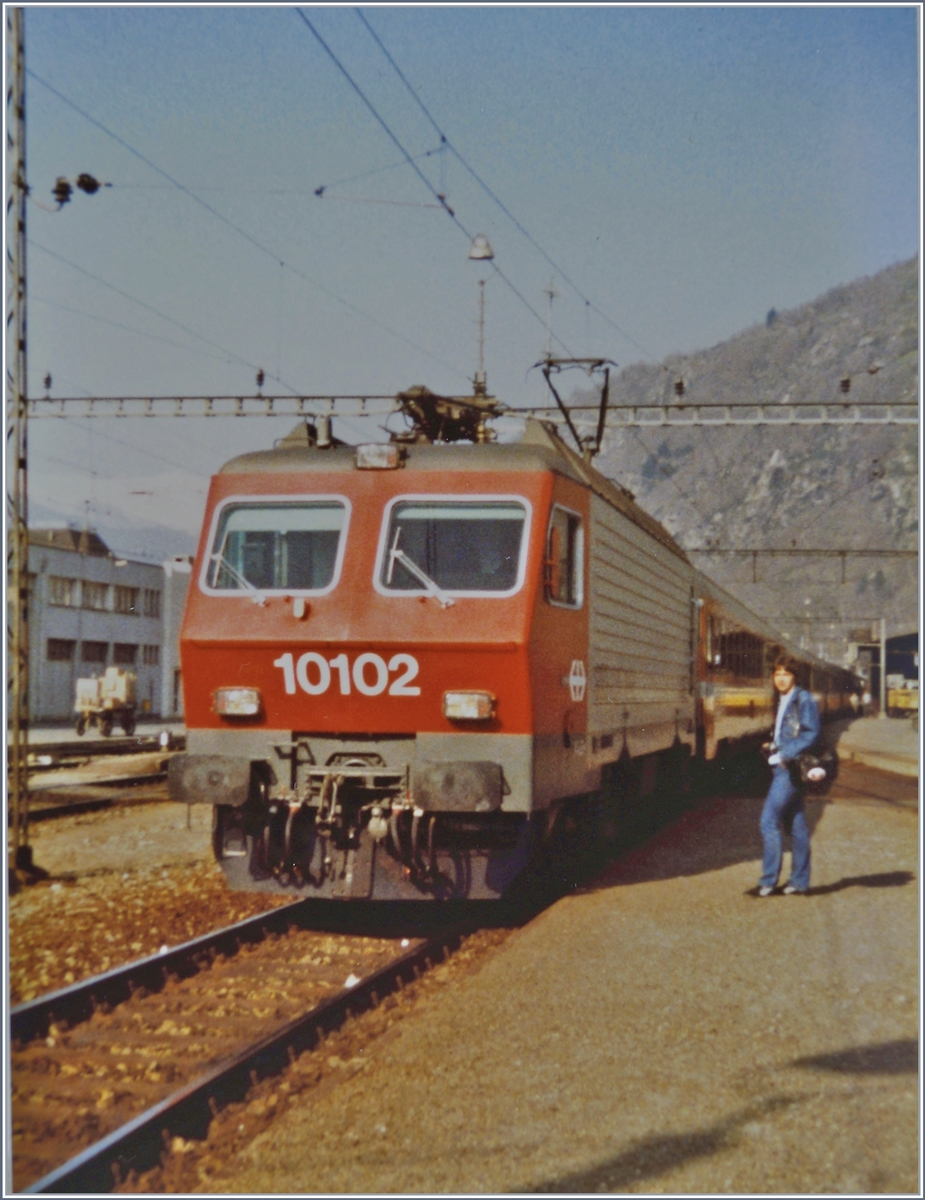 Die SBB Re 4/4 IV 10102 wartet in Brig mit ihrem Schnellzug 321 Genve/(Bern)- Brig - Milano - Venezia auf die Abfahrt.
19. April 1984