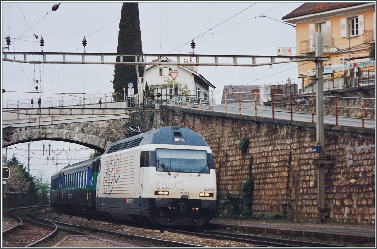 Die SBB Re 460 016  ciba  mit einem Schnellzug bei der Durchfahrt in Rivaz. 

Analogbild vom April 1995