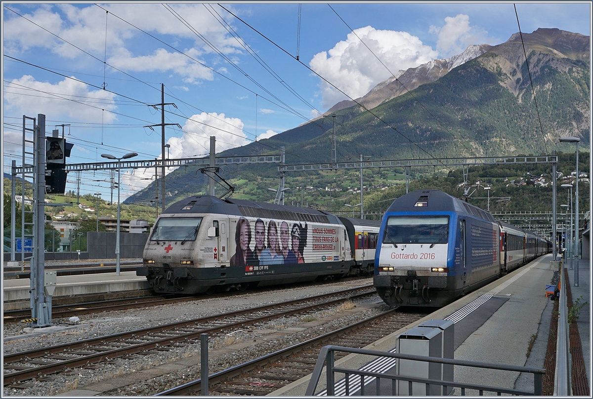 Die SBB Re 460 041-7  Rotes Kreuz  und die Re 460 079-7  Gotthard 2016  warten mit ihren Zügen nach Romanshorn und Genève-Aéroport in Brig auf die Abfahrt.
18.Sept. 2017