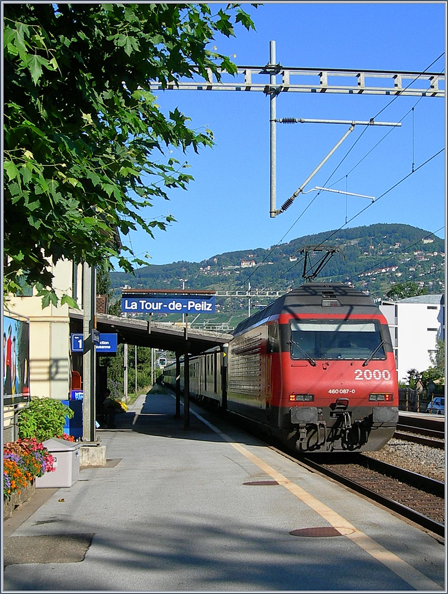 Die SBB Re 460 087 schiebt bei La Tor de Peilz ihren IR Richtung Genève. Leider nur teilweiser zu erkennen: Damals waren die EW IV noch Grün/Lichtgrau und die Walliser IR führten einen ex SNCF Gepäckwagen. 
15. August 2006