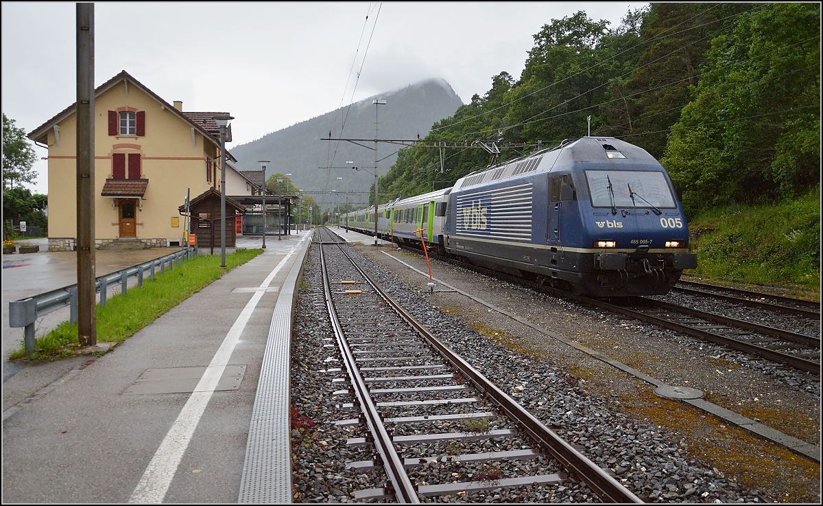 In der Spitzkehre von Chambrelien. In der Re 465 005-7 wartet bereits ein zweiter Lokf�hrer auf den Richtungswechsel. Im Hintergrund zeigt sich der markante Felsen, der das tief eingeschnittene Val Travers (mit weiterer, eigener Bahnlinie) vom Neuenburger See trennt. Juni 2016.