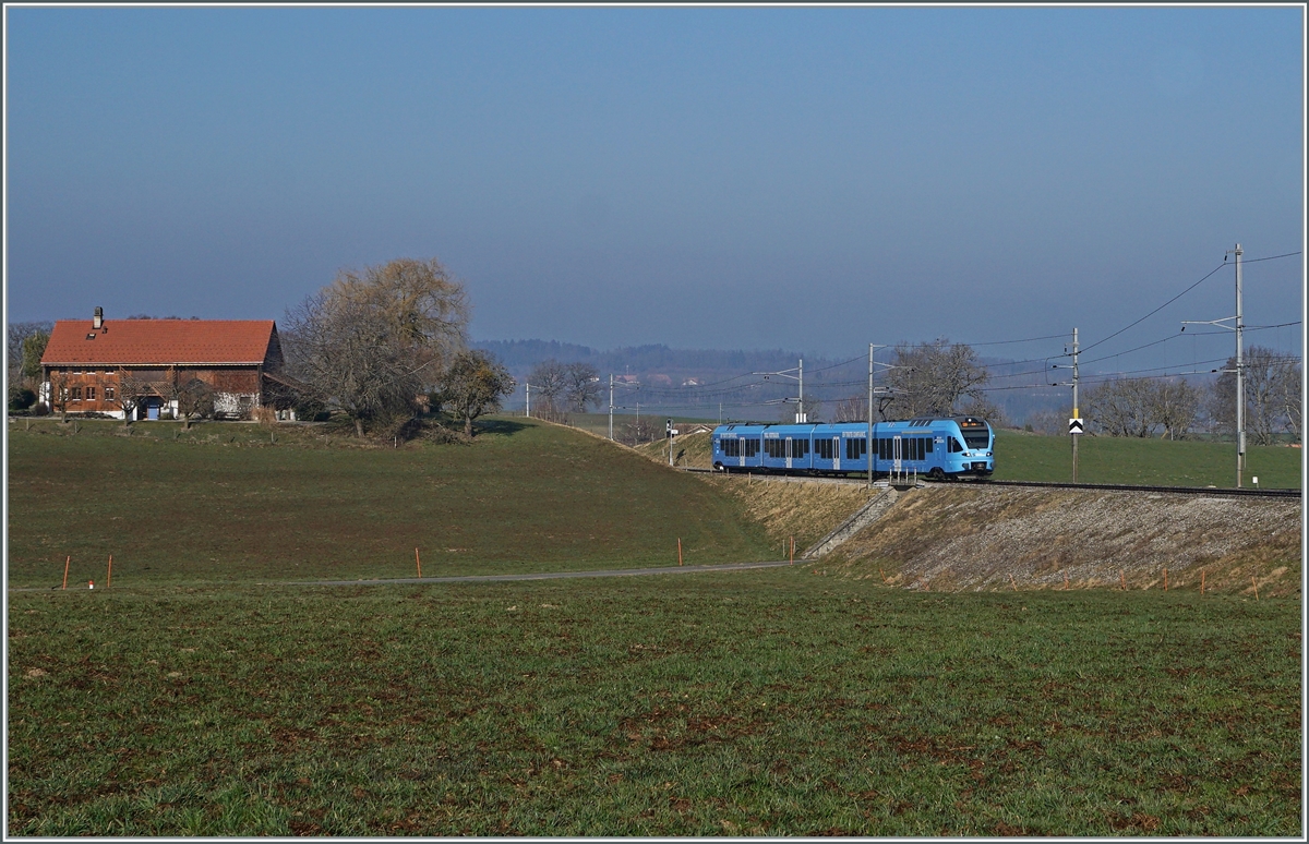 In weiten Kurven windet sich das Trasse der Strecken von Romont nach Vuisternens-devant- Romont, um die gut achzig Höhenmeter zu überwinden. Der im sehr gefälligen Werbeanstrich der  Groupe Grisoni  gehaltene TPF RABe 527 198 hat die Steigung fast geschafft und erreicht in Kürze den Bahnhof Vuisternas-devant-Romont, welcher jedoch wie alle Station zwischen Romont und Bulle nur noch dienstlichen Zwecken dienen.

1. März 2021 