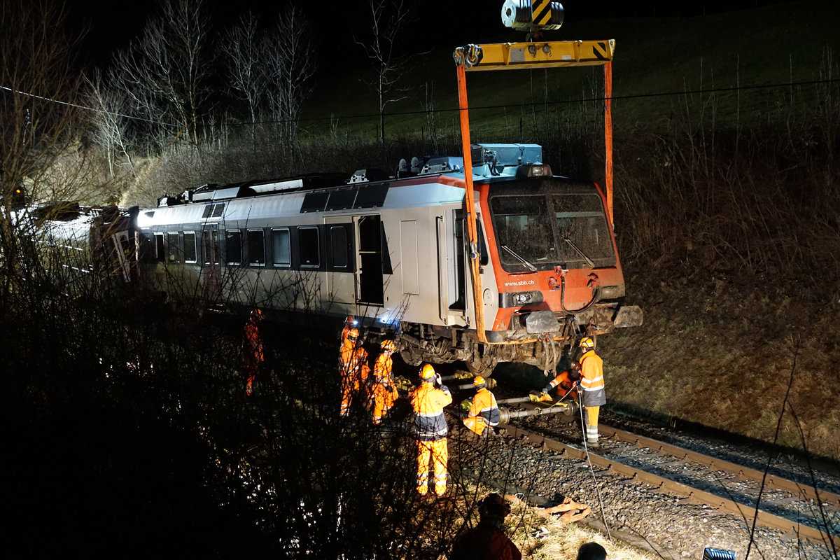 JAHRESR�CKBLICK 2018
von Walter Ruetsch
Serie Nr. 1
Bei Lommiswil entgleiste am 22. Januar 2018 nach einem Erdrutsch ein Zug. Der dreiteilige Domino mit dem Triebwagen RBDe 560 253 musste w�hrend der Nacht geborgen werden, da der Kran ab Basel, Del�mont, Moutier erst am sp�ten Nachmittag in Oberdorf eintraf. Die Strecke blieb mehrere Tage unterbrochen, es verkehrten Ersatzbusse.
N�chtliche Bergungsarbeit des Domino vom 23. Januar 2018.
Erlaubter Fotostandort auf freiem Feld. Bildausschnitt Fotoshop.
