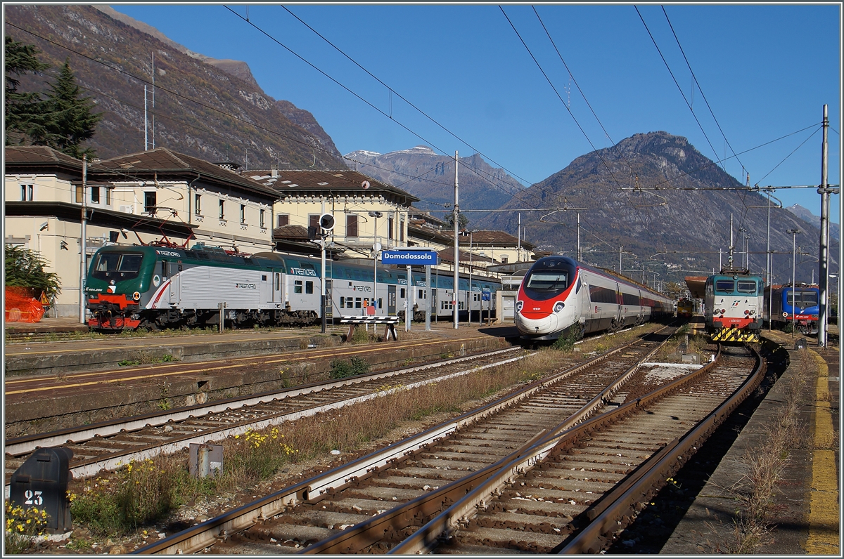 Neben der abgestellten FS E 656 431 und einer auf die Abfahrt nach Milano wartenden Trenord E 464 wartet auch ein SBB ETR 610 (RABe 503) in Domodossoala auf die Abfahrt.

26. Okt. 2015