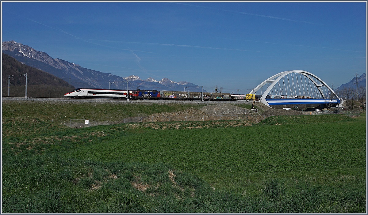 Während ein Güterzug in Richtung Wallis fährt, ist der SBB ETR 610 auf dem Weg von Milano nach Genève und überquert bei Massogex die Rhone. 

27. März 2017