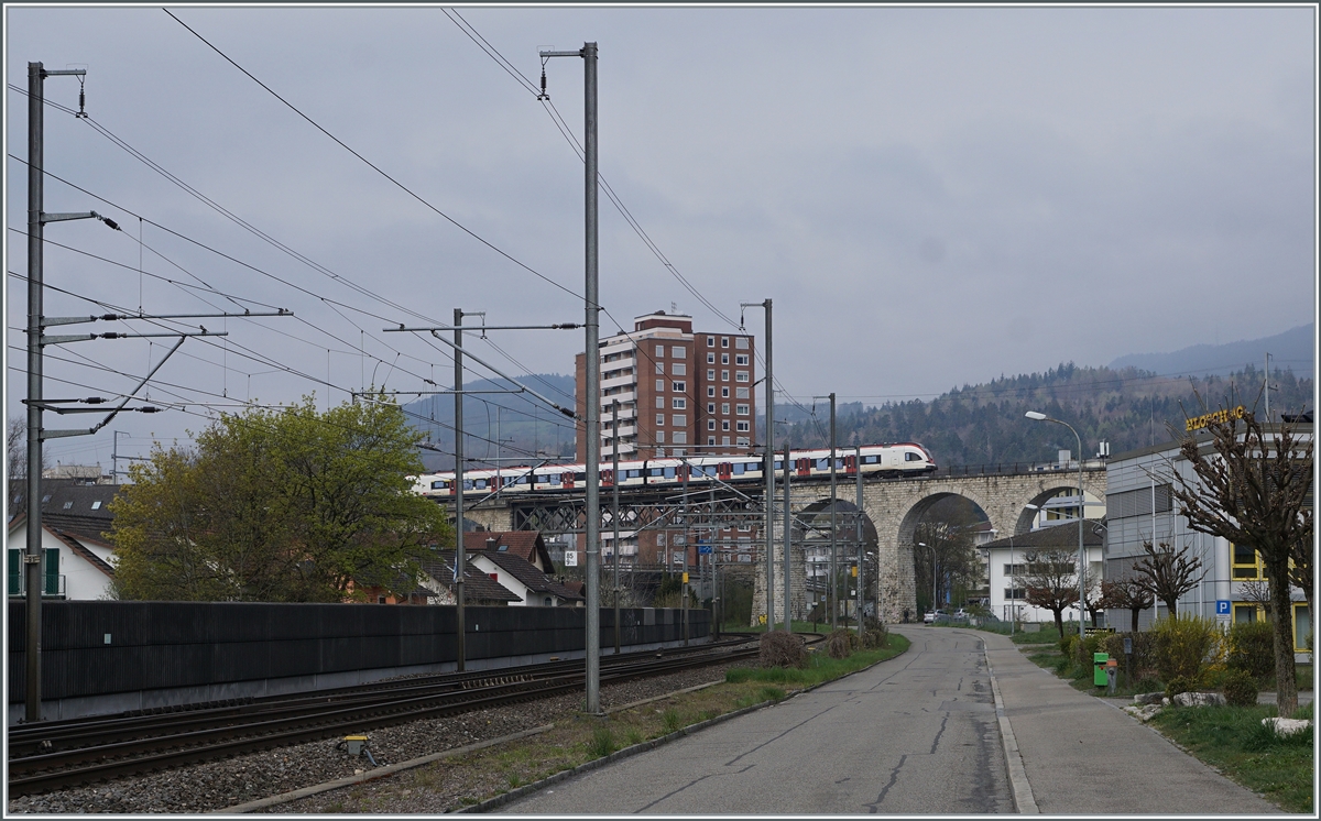 Während unten die Strecke von Biel/Bienne nach Olten verläuft, fährt im Hintergrund ein SBB RABe 522 als RE in Richtung Meroux TGV. Der Zug fährt über das Möösliviadukt und wird unmittelbar darauf seinen nächsten Halt Grenchen Nord erreichen. Die Strecke Lengnau - Grenchen Nord - Moutier gehört der BLS und firmt unter MLB.

18. April 2021