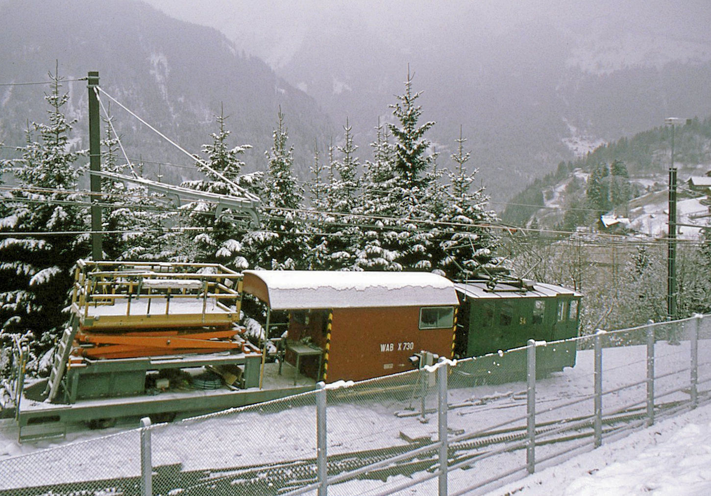  Aus dem Leben der Wengernalpbahn Lok 54 : Noch eine Aufnahme auf der hier als Wartegleis genutzen alten Linie nach Lauterbrunnen. Leider konnte ich nicht näher an den Zaun heran für ein besseres Bild. 30.Dezember 1996 