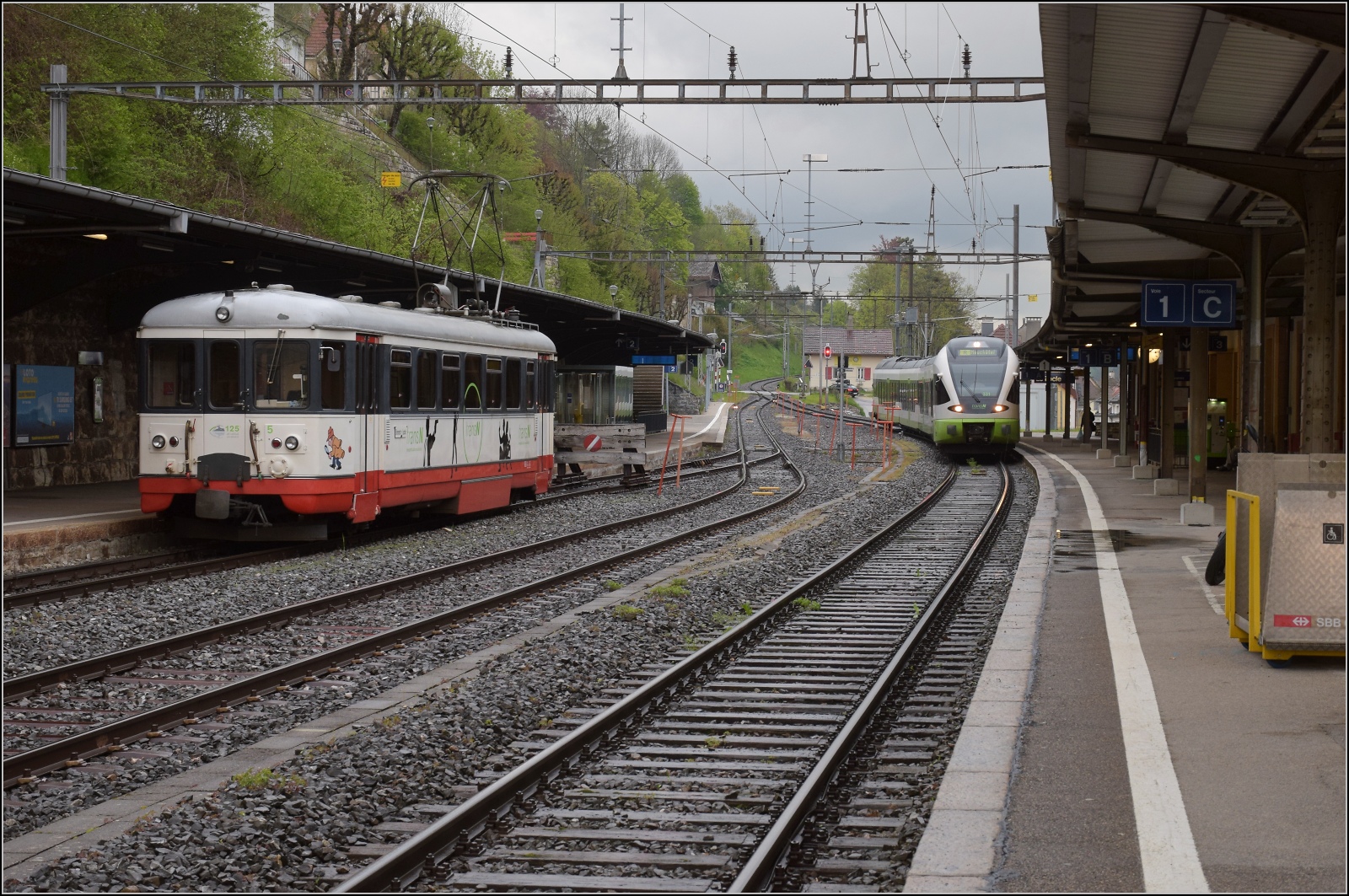 BDe 4/4 5 der  Régional des Brenets , heute TransN, hat bald ausgedient und ein Bus wird auf der Bahnstrecke fahren. Der jüngere TransN-Bruder vom Typ Flirt I, RABe 527 331 trifft derweil in Le Locle ein. Mai 2023.