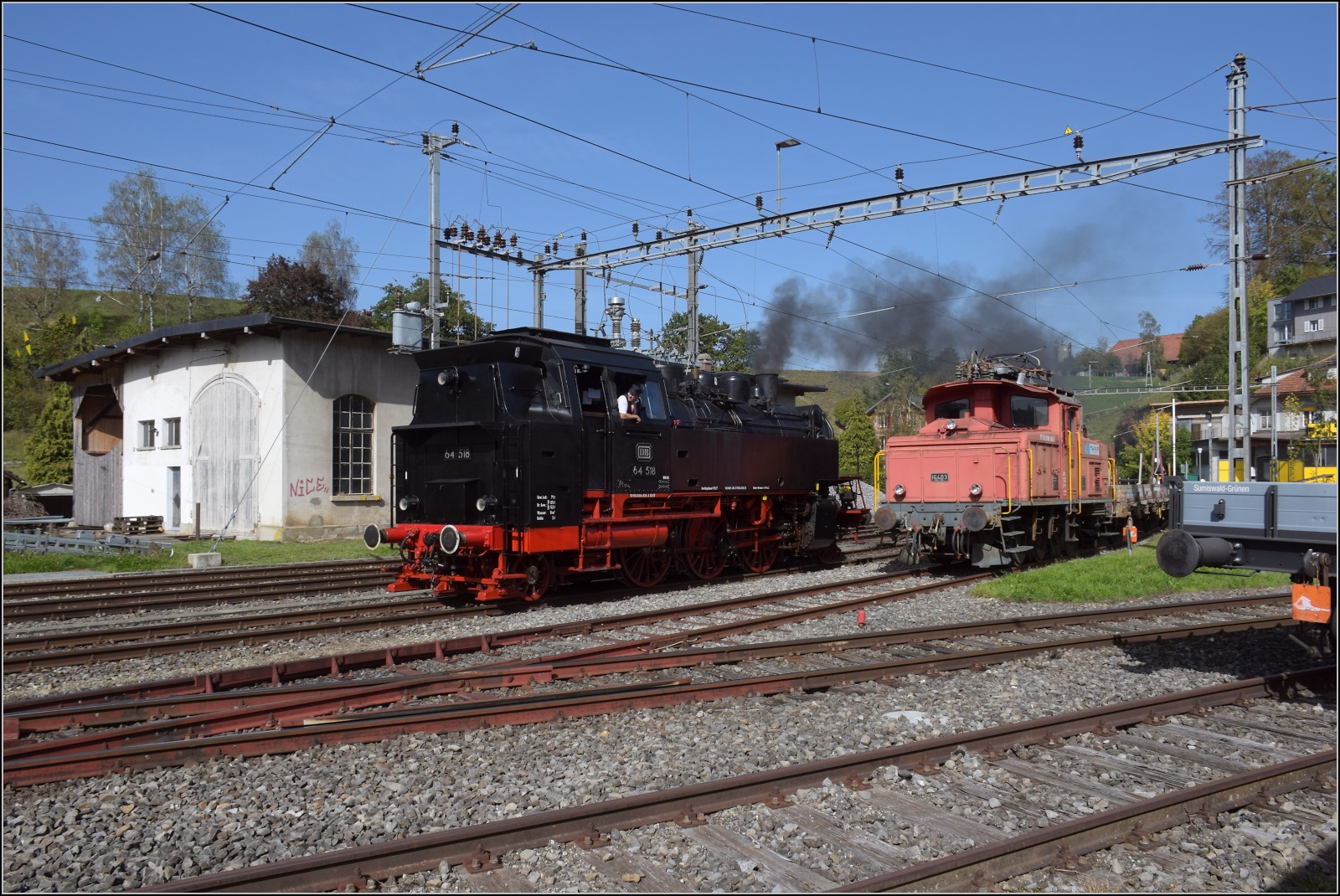 Dampftage Huttwil mit frisch genesenem Bubikopf. 

In Sumiswald-Grünen steht mit Ee 3/3 16403 ein echter Oldtimer im Arbeitsalltag und schon kommt 64 518 hinter der Rangierlok durchgefahren zur Rückleistung. Oktober 2023.