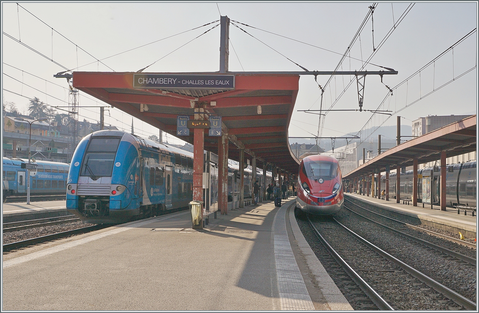 Der FS Trenitalia ETR 400 050 ist auf dem langen Weg von Milano Centrale nach Paris Gare de Lyon als FR 9292 unterwegs und verlässt nach einem kurzen Halt den Bahnhof von Chambéry-Challes-les-Eaux. Neben der Tatsache, dass der FS ETR 400 für mich zu einem der schönsten (modernen) Züge gehört, trägt auch die schwere SNCF 1500 Volt Gleichstrom Fahrleitung auf interessante Weise zu diesem Bild bei.
Daneben steht ein TER in dne neune Fraben von  RegionAlps - Auverne . 

22. März 2022 