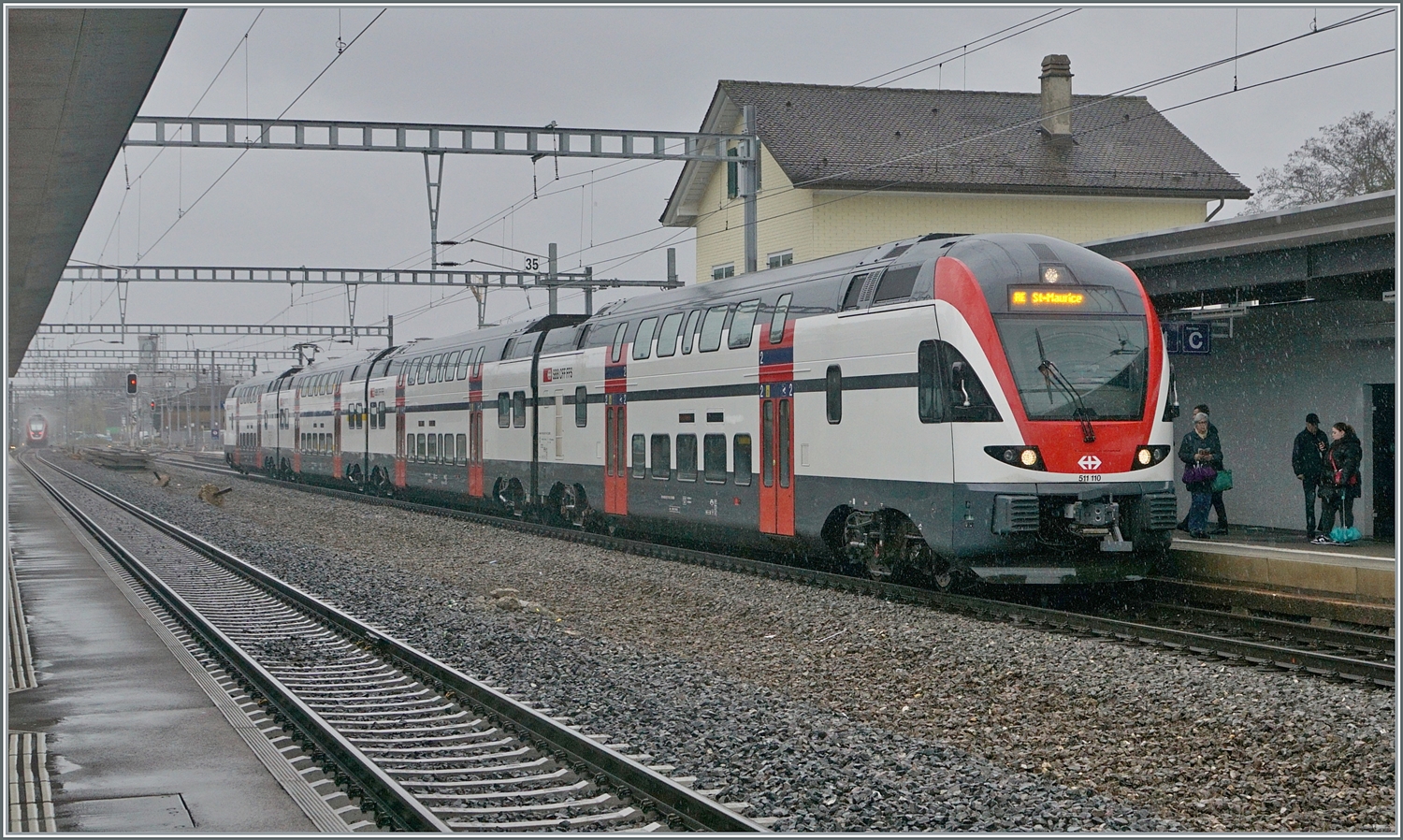 Der SBB RABe 511 110 als RE 33 von Annemasse nach St-Maurice beim Halt in Gland. Weit im Hintergrund ist ein SBB RABDe 502  Twindexx  auf der Fahrt nach Genève Aéroport zu erkennen.
Seit meinem letzten Besuch in Gland vor sieben Jahren wurde der Bahnhof umgebaut und verlor das Gleis 2, welches über eine Weiche vom Gleis 1 Seite Lausanne abzweigte und mit einer weitern Weiche Seite Genève ins Gleis 3 mündete und mir somit der betriebliche Vorteil eines solchen Gleises nicht so ganz klar war.

22. Feb. 2024