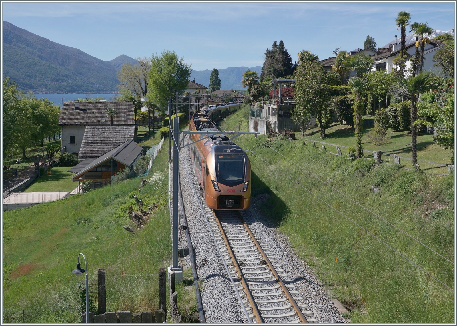 Der SOB RABe 526 118  Treno Gottardo  ist zwischen Locarno und Tenero als IR26 2324 nach Basel SBB unterwegs. Es ist eine der wenigen Stellen an der stark verbauten Strecke, wo mit etwas Geschick doch noch etwas Grün mit aufs Bild zu bekommen ist, selbst, wenn der nahe See nur andeutungsweise im Hintergrund zu erkennen ist.

26. April 2023