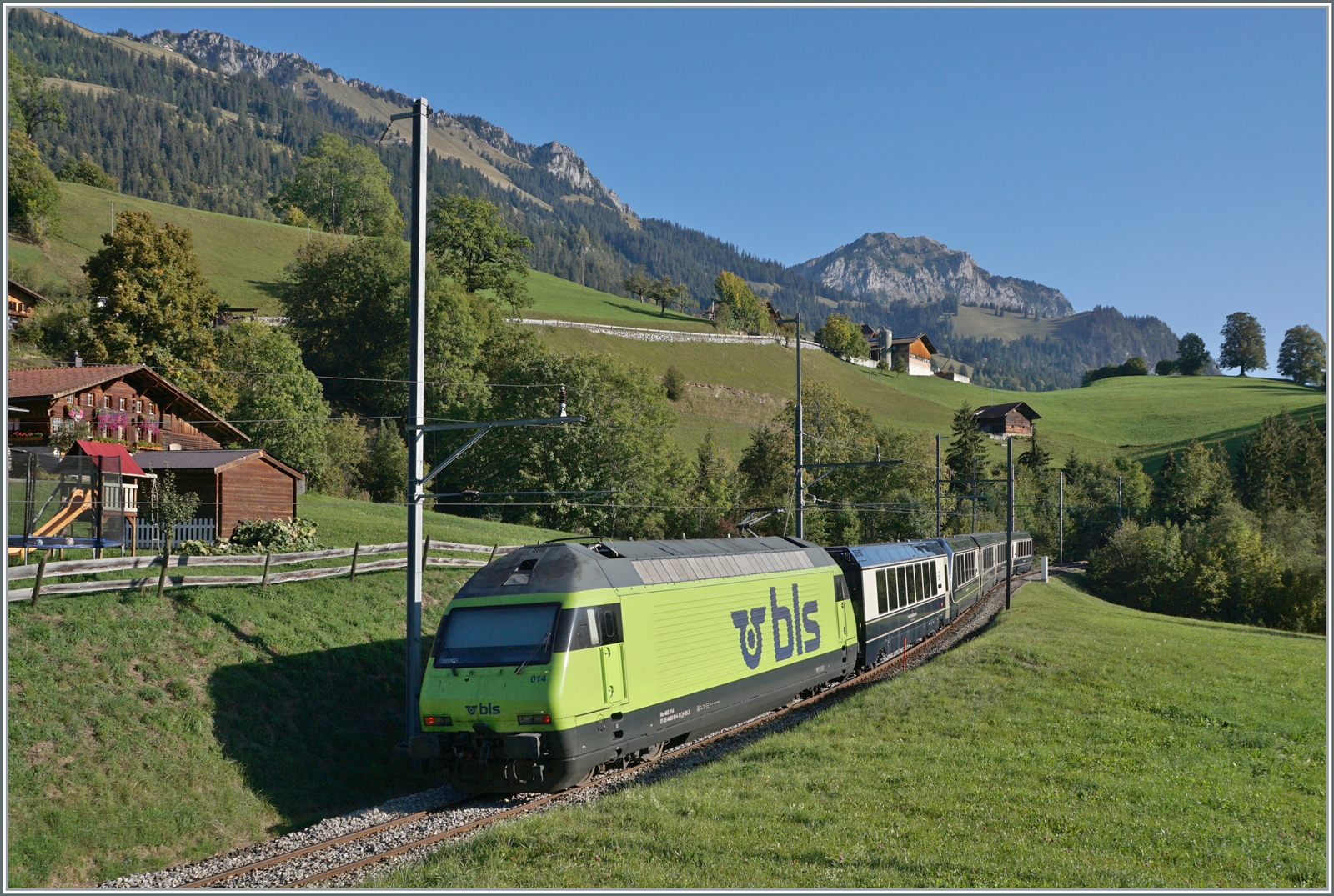 Die BLS Re 465 014 (UIC 91 85 4465 014-9) ist kurz nach der Haltestelle Enge im Simmental, welche der Zug ohne Halt passiert hat, mit dem GoldenPass Express GPX 4064 von Montreux nach Interlaken Ost unterwegs.

7. Okt. 2023