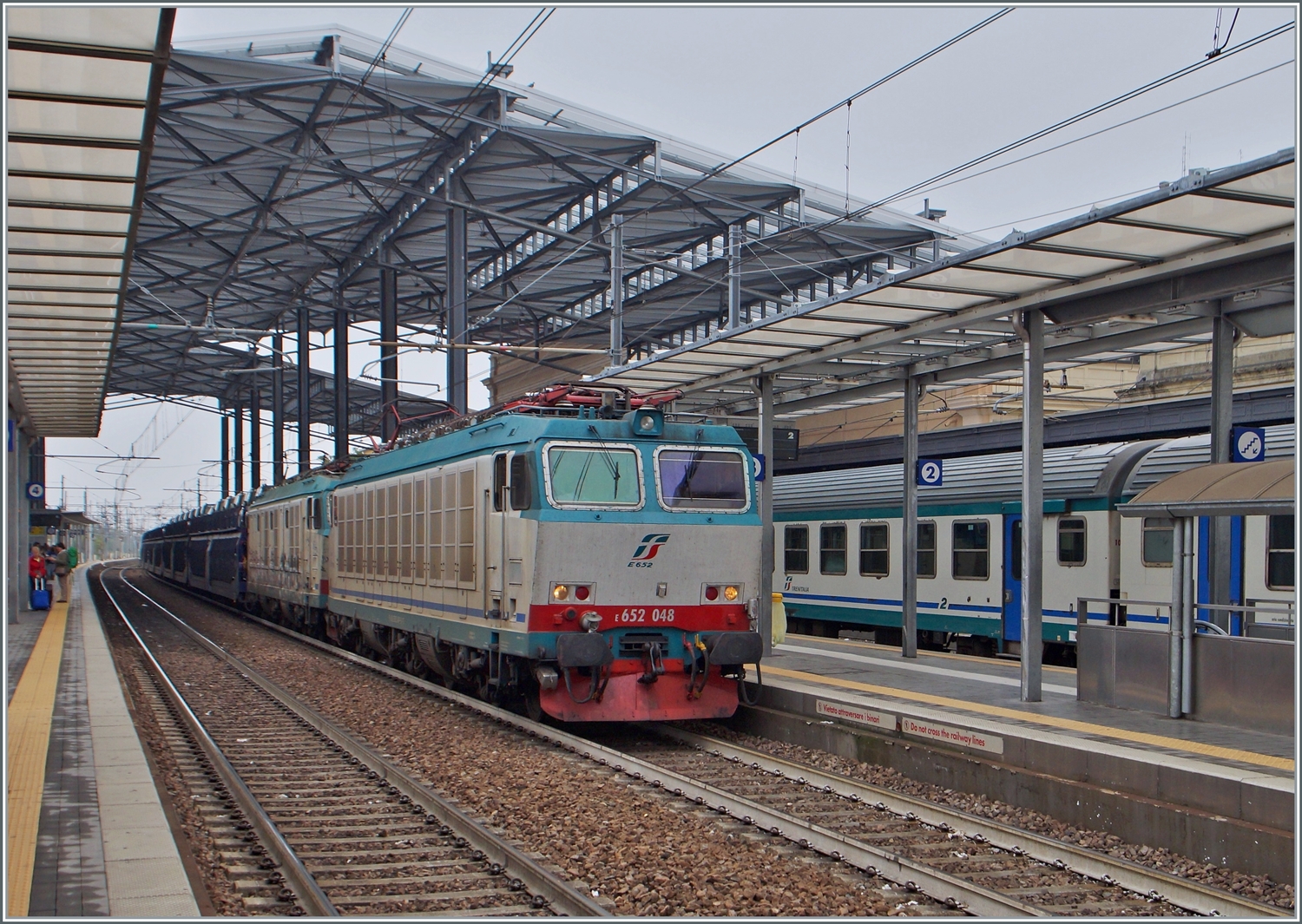 Die FS Trenitalia E 652 048 und eine weitere fahren mit einem Autoverladewagen durch den Bahnhof von Prama in Richtung Süden.

20. Sept. 2014