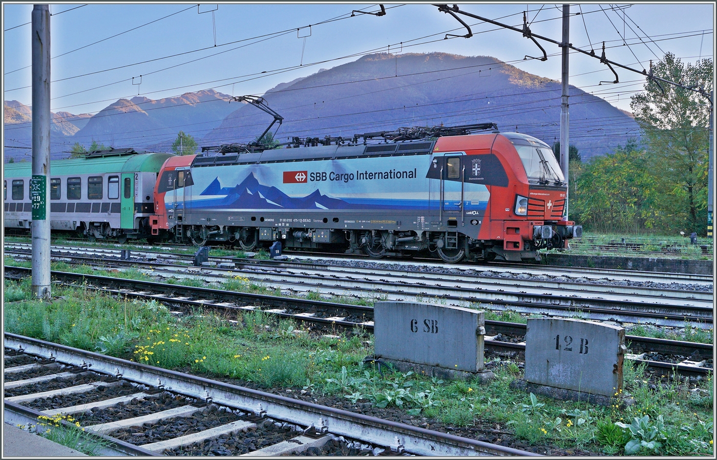 Die SBB Cargo International 193 475 wartet mit einer RoLa in Domodossola auf die Weiterfahrt nach Novara. Zum Fahrplanwechsel 2025/2026 wird die Verbindung eingestellt, da viel zu zahlreichen Baumassnahmen zur Verbesserung des Güterverkehrs diesen zur Zeit so stark beeinträchtigen, dass eine vernünftige Betriebsführung nicht mehr möglich ist. 

31. Okt. 2024