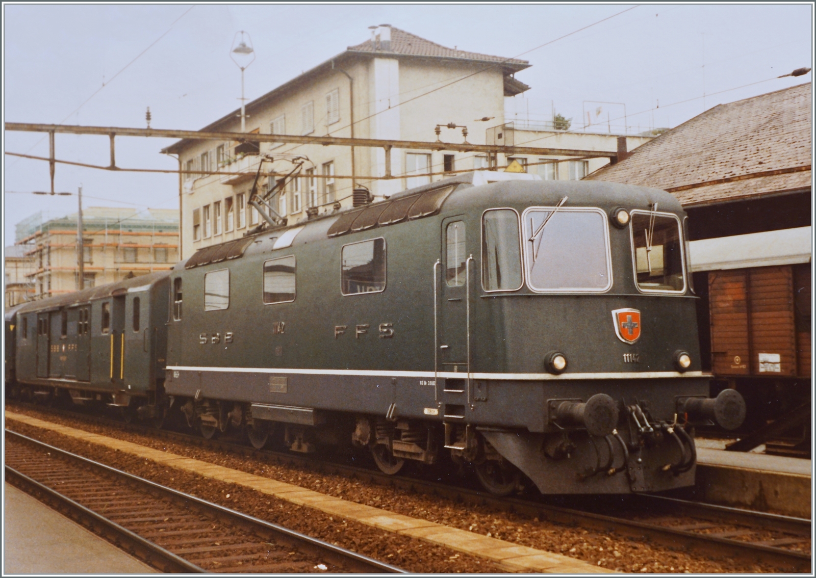 Die SBB Re 4/4 II Prototypen und der ersten Serie wurden grundsätzlich mit Scherenstromabnehmern ausgestattet, aber es gibt Ausnahmen, wie dieser zwei Bilder zeigen: Die SBB Re 4/4 II 11143 wartet in Aarau mit einem Schnellzug nach Zürich Flughafen (via Brugg - Zürich HB) auf die Abfahrt.. 

Analogbid vom 24. Juli 1984