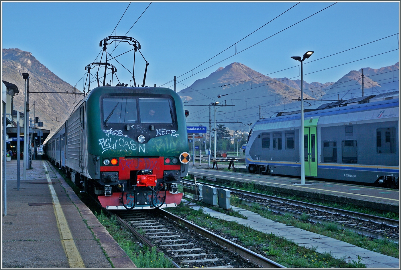 Die Trenord 464 446 (91 83 2464 446-0 I-TN) ist mit ihrem  Regionale  aus Milano in Domodossola angekommen und wendet hier, weshalb für einen kurzen Moment beide Stromabnehmer an der Gleichstrom Fahrleitung anliegen. 

31. Okt. 2024 