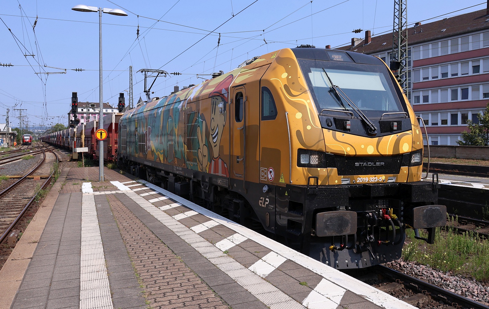 Dispo-Tf 2019 323-5 REV/Stadler Valencia/14.11.24  mit langem Voestalpine/Innofreight Rocktainer ORE Ganzzug aufgenommen in Koblenz am 12.08.2025