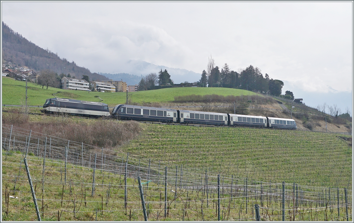 Eine MOB Ge 4/4 Serie 8000 ist mit ihrem GoldenPass Express bei Planchamp von Montreux nach Interlaken Ost unterwegs. Der Zug wurde in Zweisimmen umgespurt und von einer BLS Re 465 übernommen.

28. Feb. 2024