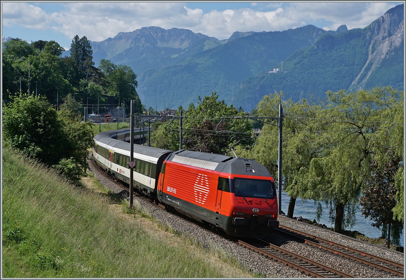 Eine SBB Re 460 ist mit ihrem IR  90 von Genève Aéroport nach Brig bei Villeneuve unterwegs. 

5. Juni 2024