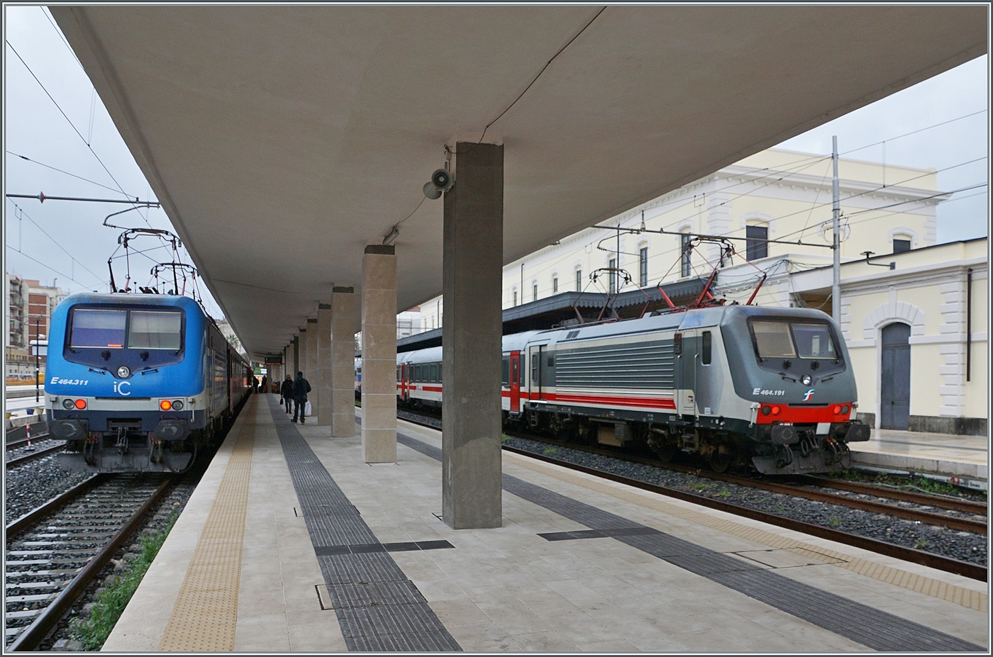 Während in Siracusa links im Bild die FS Trenitalia E 464.311 (und einer weiteren Lok an der Zugsspitze) mit ihrem Nachtzug aus Roma Termini ihr Ziel erreicht haben, stellt recht im Bild die FS Trenitalia E 464 191 ihren iC 724 nach Roma bereit. 

16. März 2026
