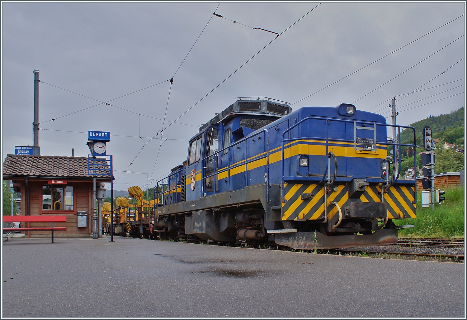 Wo am Wochenende Dampflok dampfen, dieseln an Werktagen Dieselloks: Die MOB Gm 4/4 2004  Albeuve  steht mit einem Dienstgüterzug in Blonay und wartet auf die Abfahrt nach Chamby. 

11. Mai 2023