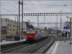 Die SBB Cargo Re 193 472 fährt mit einem langen Rail-Care Zug durch den Bahnhof von Morges.