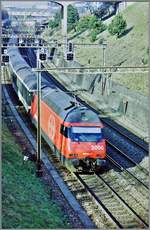 Eine SBB Re 460 auf dem damals noch dreigleisigen Abschnitt kurz nach Lausanne schiebt ihren, damals noch grünen EW IW Zug in Richtung Genève. Heute wird dieser Streckenteil auf vier Gleise ausgebaut. 

Frühjahr 1998