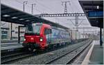 Die SBB Cargo International Re 193 472 mit einem sehr langen Rail-Care Zug bei der Durchfahrt in Morges.